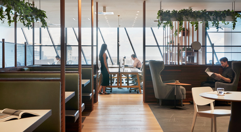 An interior shot of a vibrant Sydney Coworking Area in The Executive Centre, bustling with patrons at tables, fostering a warm and social environment