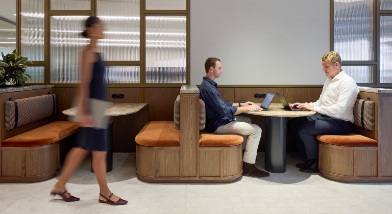 Colleagues sitting at a table in the coworking lounge, collaborating on a project