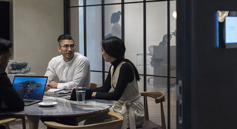 レンタルオフィスにある高級貸し会議室で打ち合わせをしている人々