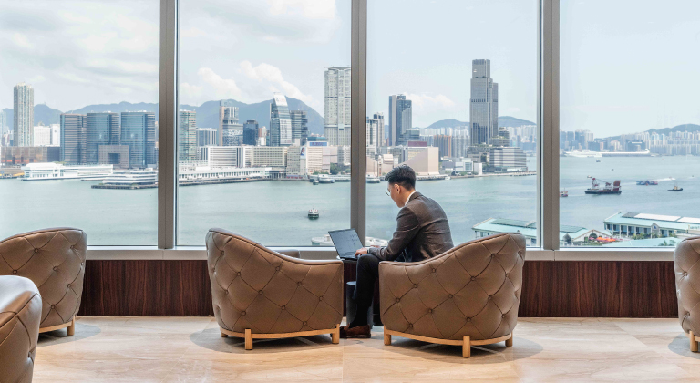 Executive in Private Office with Hong Kong Skyline View