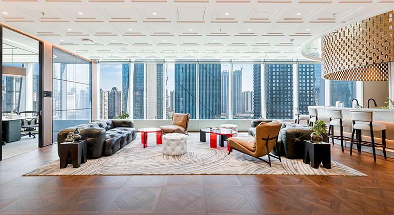 Bright lounge area with a large window showcasing a city view, close to a barista bar and meeting room